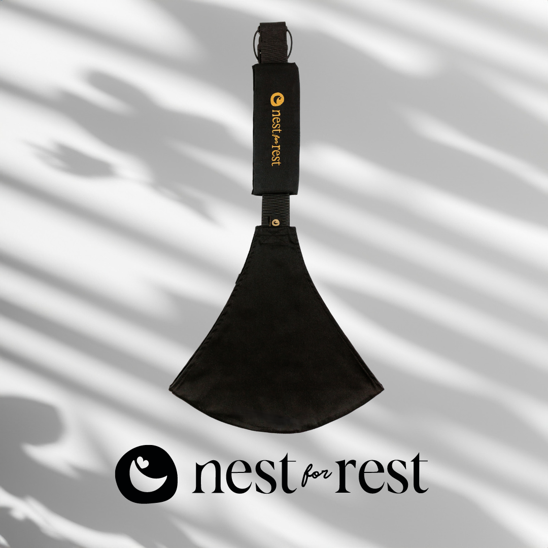 Nest for Rest Black toddler carrier featuring a sleek design with a golden logo, shown against a light background with shadow effects. The carrier is compact and designed for comfort and style, suitable for toddlers aged 9 months to 4 years.