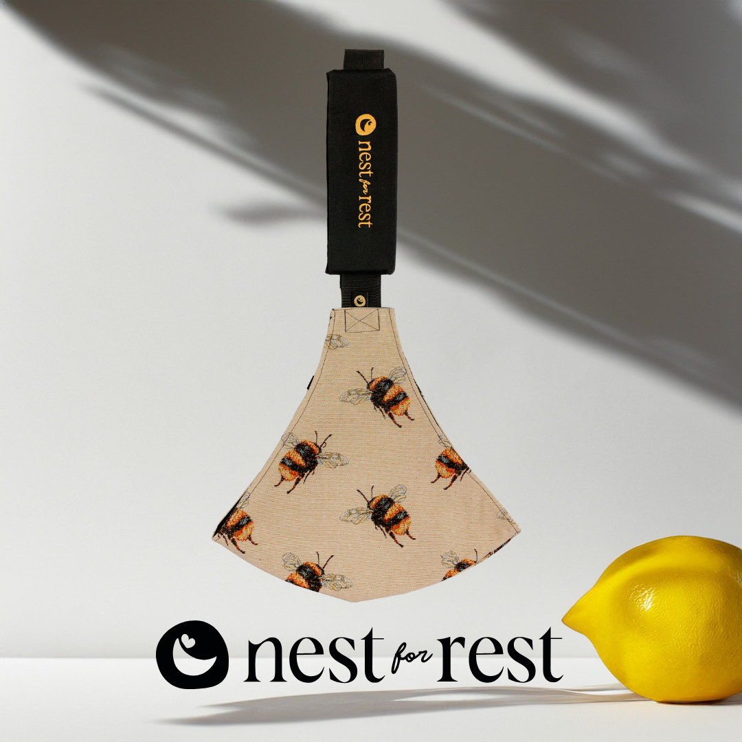 Nest for Rest Bumbleebee toddler carrier featuring a sleek design with a golden logo, shown against a light background with shadow effects and lemon. The carrier is compact and designed for comfort and style, suitable for toddlers aged 9 months to 4 years.