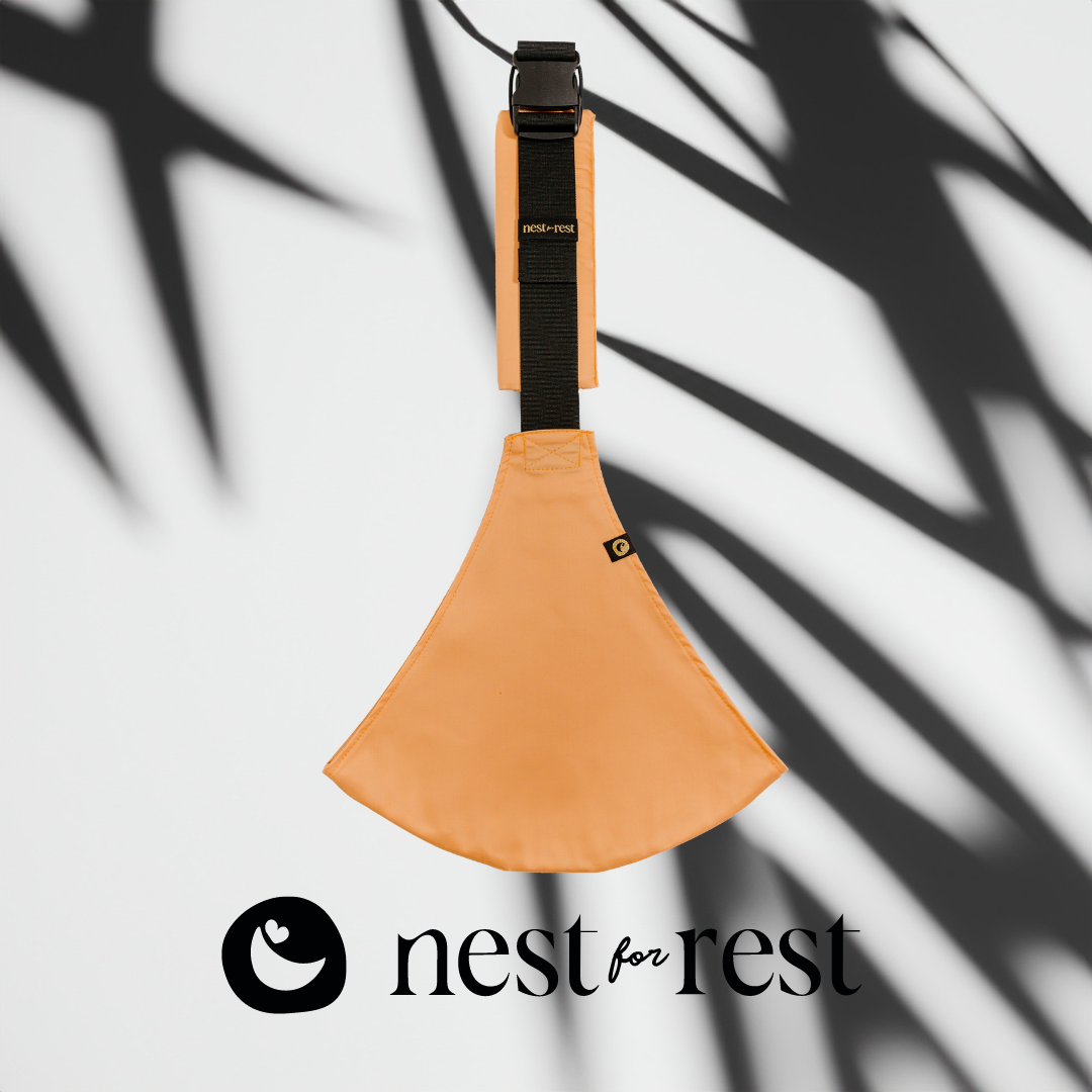 Nest for Rest Peach toddler carrier featuring a sleek design with a black logo, shown against a background with lemons. The carrier is compact and designed for comfort and style, suitable for toddlers aged 9 months to 4 years.